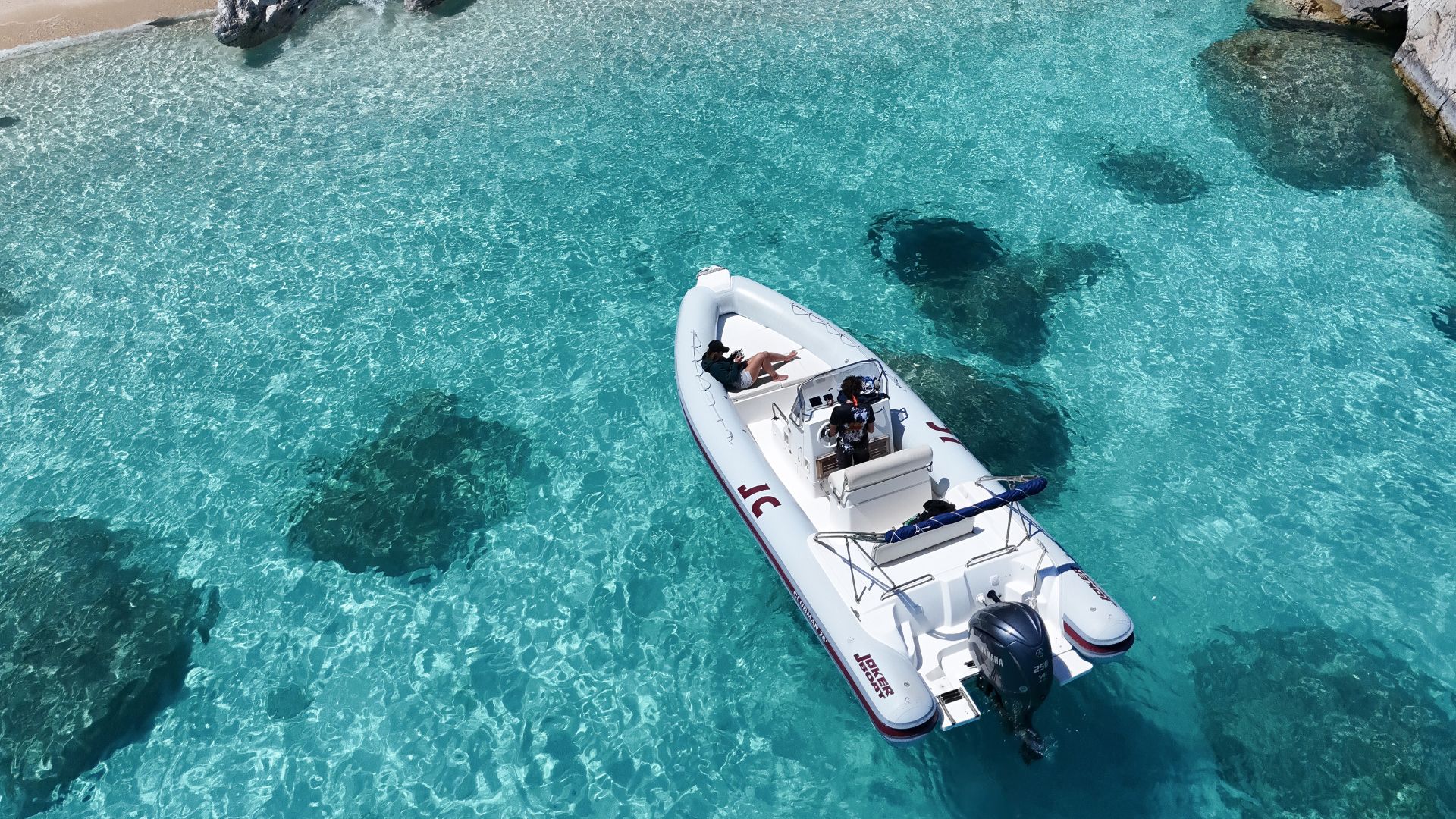 Dinghy sailing in the crystal clear waters of Cala Luna