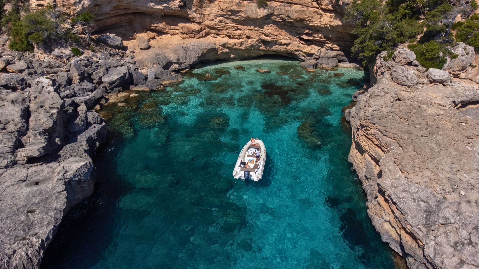 Dinghy sailing along the coast of Baunei