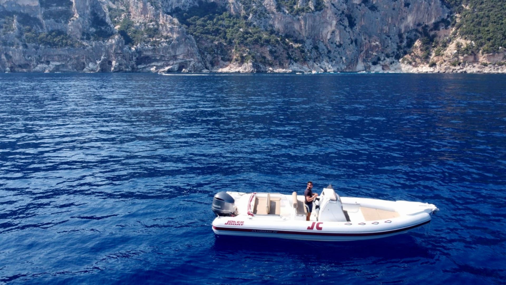 Dinghy sailing in the crystal clear waters of the Gulf of Orosei