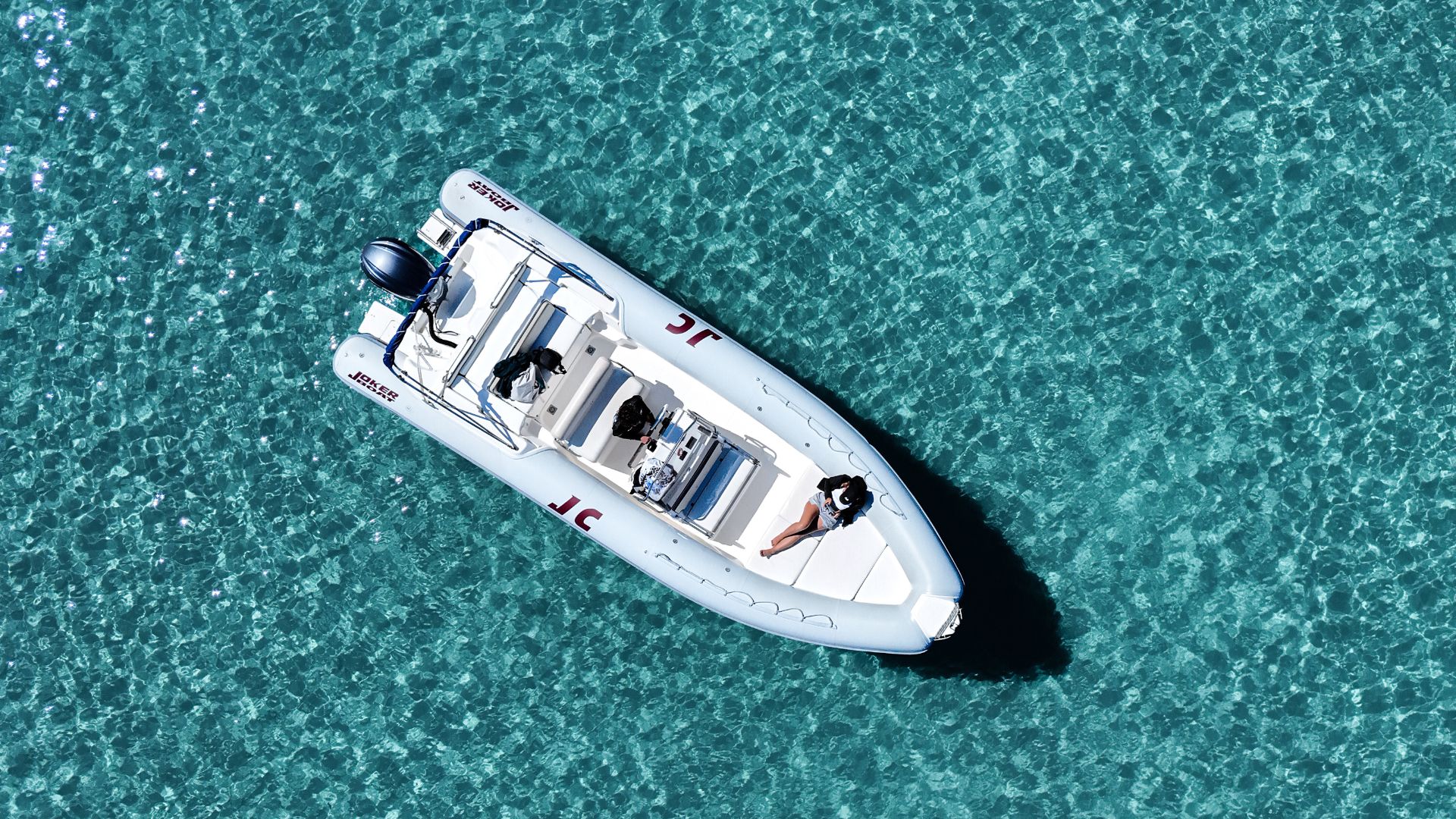 Dinghy sailing in the crystal clear waters of the Gulf of Orosei