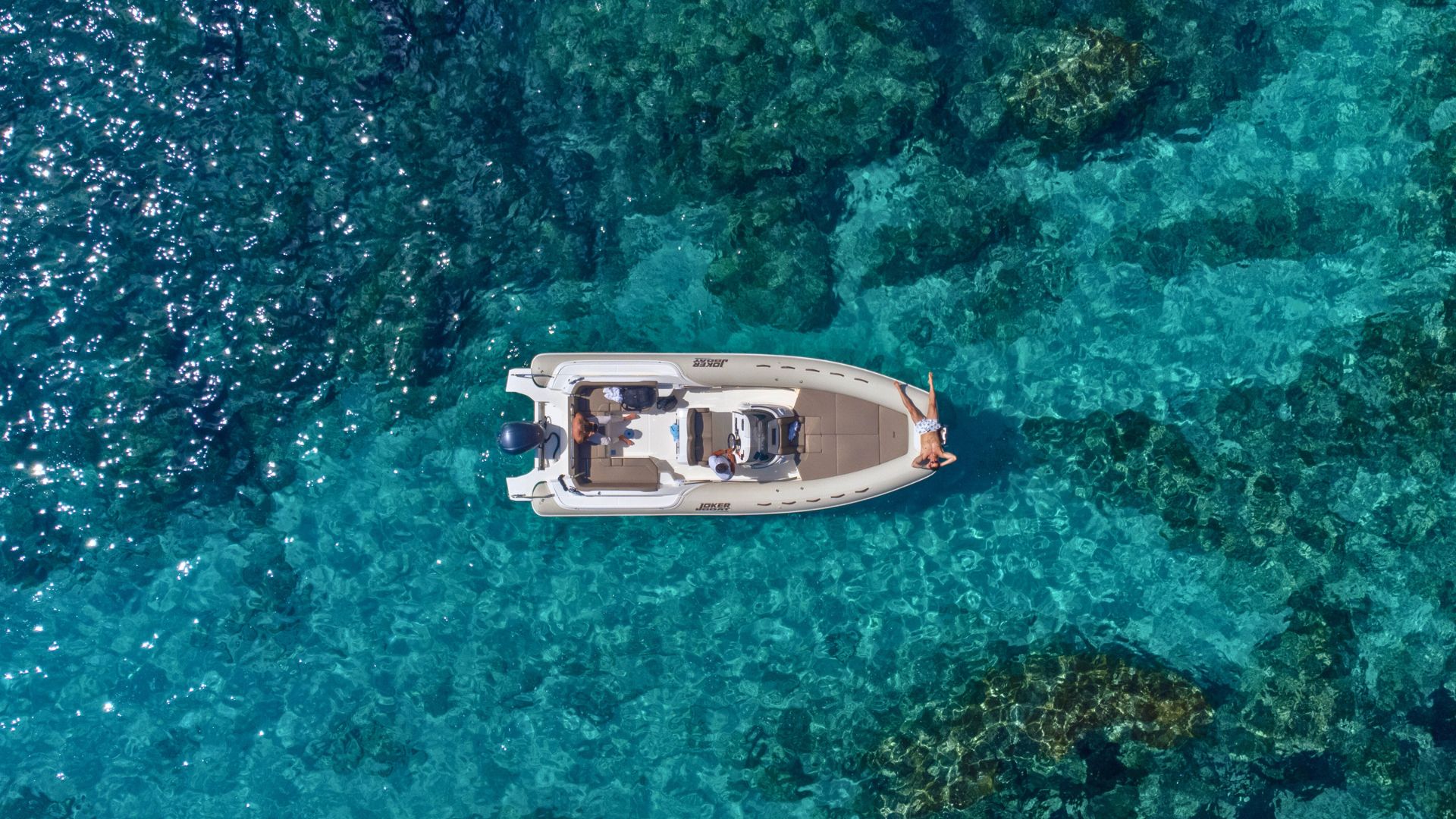 Dinghy sailing in the crystal clear waters of Cala Mariolu