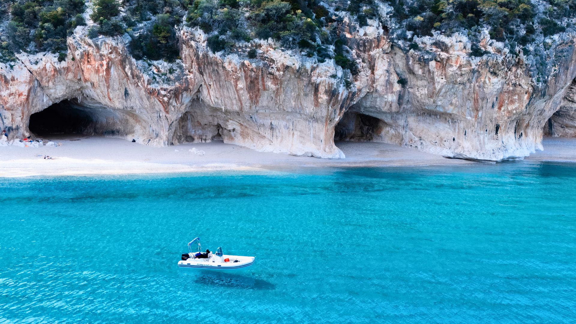 Gommone vicino alle grotte naturali di Cala Luna
